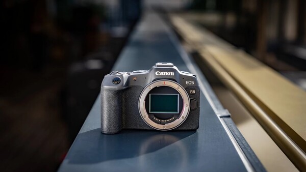 Canon EOS R5 mirrorless camera positioned on a narrow metal rail with blurred background.