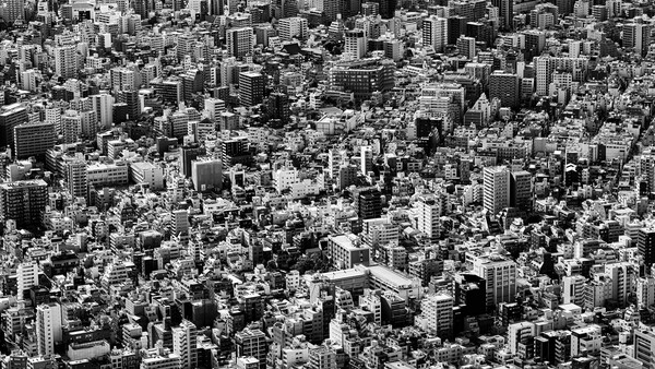 Dense urban cityscape with hundreds of tightly packed buildings viewed from above in black and white.