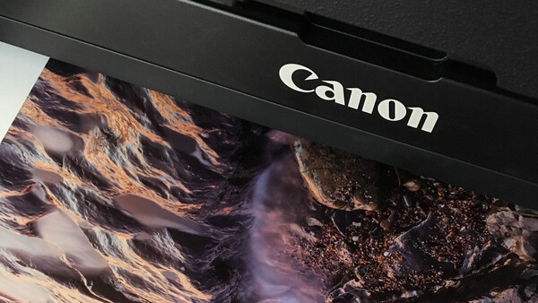 Canon printer displaying a vibrant landscape photograph with warm golden and purple tones.