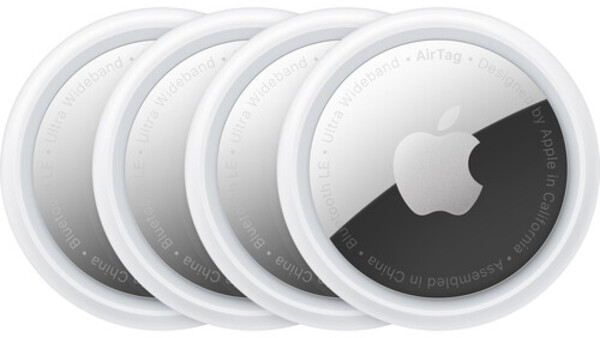 Four Apple AirTag tracking devices arranged in a row, showing white circular design with dark tracking element visible on rightmost unit.