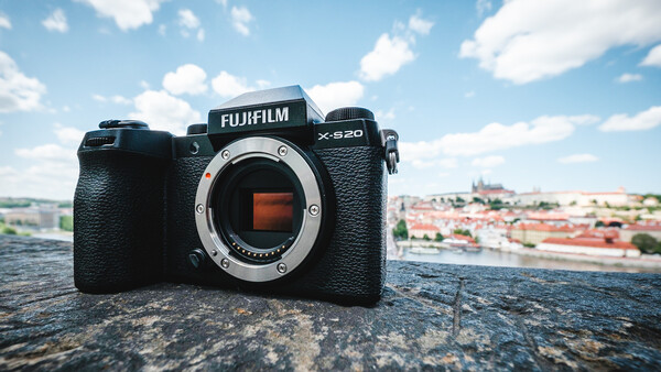 Fujifilm X-S20 camera body displayed on a stone surface with a cityscape in the background.