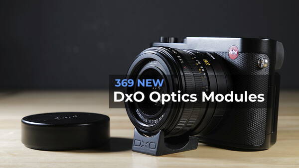 DxO camera with interchangeable lens module and lens cap on wooden surface.