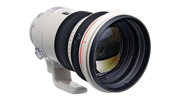 White and black telephoto lens with internal focus mechanism and rounded front element.