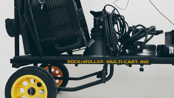 Rock n Roller Multi-Cart Rie equipment cart with yellow wheel and coiled cables on white background.