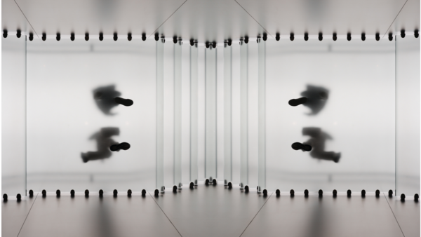 Mirrored symmetrical composition with blurred figures in motion against spiral notebook pages.