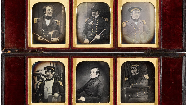 Collection of 14 daguerreotypes arranged in a wooden case with red velvet lining.