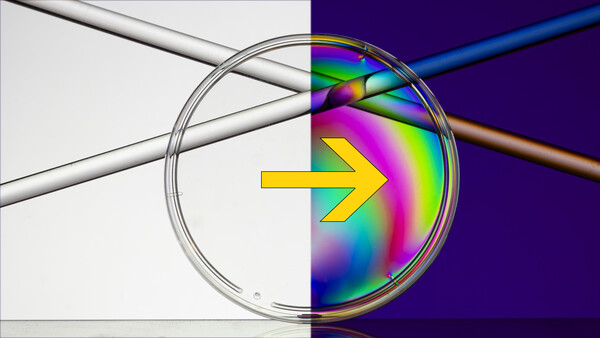 Illustration of light refraction through a spherical lens showing a colorful spectrum projection.