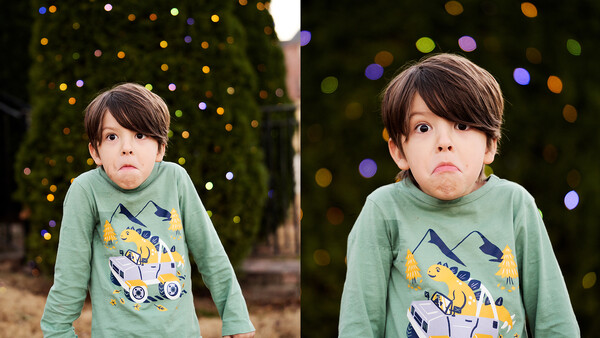 Young child with serious expression wearing green long-sleeve shirt with graphic design, photographed against blurred bokeh background.