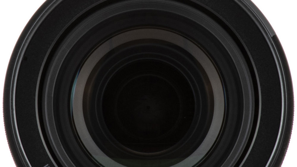 Close-up view of concentric lens elements receding into darkness, showing the optical barrel of a camera lens.