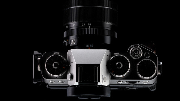 Top-down view of a rangefinder film camera with interchangeable lens mounted above.
