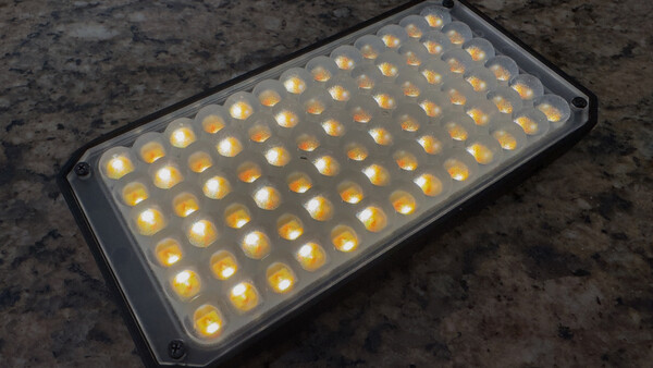 LED panel with approximately 80 warm-toned light sources arranged in a rectangular grid pattern.