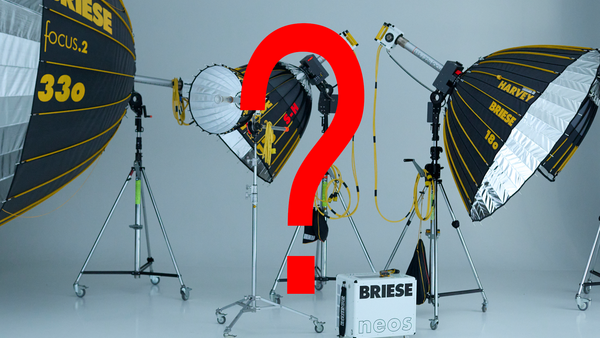 Professional lighting setup with three parabolic reflectors and a large red question mark in the center.