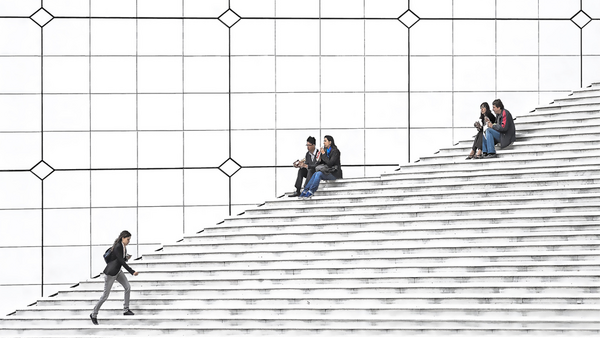 People scattered across a monumental staircase, some climbing, others sitting and socializing on the steps.