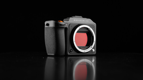 Hasselblad mirrorless camera body with exposed sensor against black background.