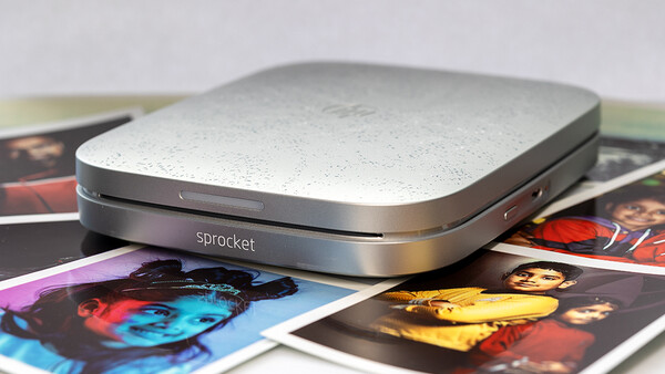 Sprocket portable photo printer positioned on colorful printed photographs.