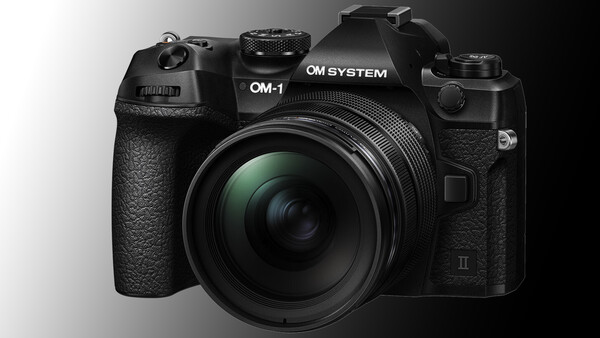 OM System OM-1 mirrorless camera with attached lens, front three-quarter view against neutral background.