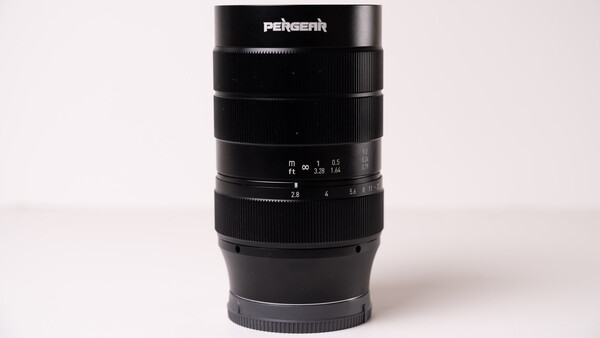 Pergear telephoto lens with focus ring and aperture markings displayed against neutral background.