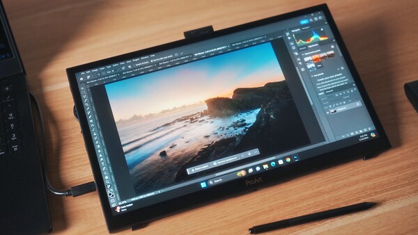 Screenshot of Photoshop displaying a coastal landscape photograph with adjustment panels open on a portable display tablet.