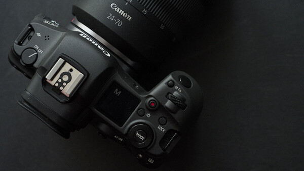Canon EOS R5 camera with RF 24-70mm lens mounted, displayed from above on dark background.