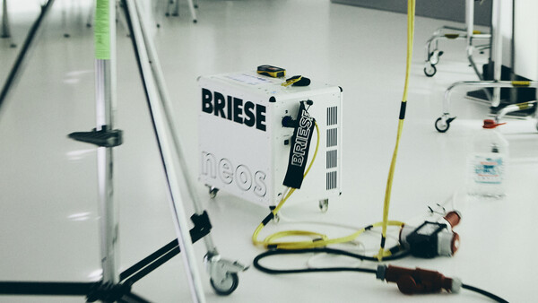 Overhead view of a Briese lighting unit on a white floor with cables and grip equipment arranged around it.