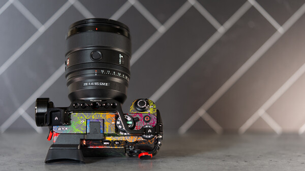 Camera lens mounted on disassembled camera body showing internal circuitry and components.