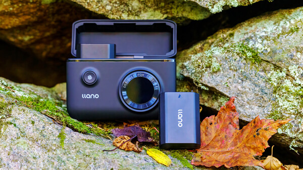 Liano instant camera and Oion battery pack displayed on moss-covered rock with autumn leaves.