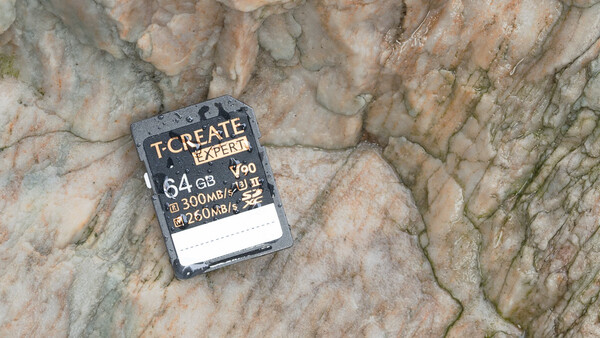 T-Create Expert 64GB SD card displaying 300MB/s write speed specifications on textured stone surface.