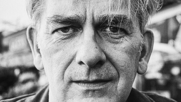 Black and white portrait of an older man with furrowed brow and direct gaze.
