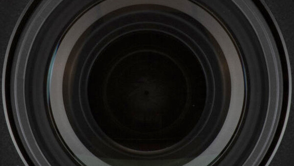 Concentric circular lens elements receding into darkness, showing internal optical glass geometry.