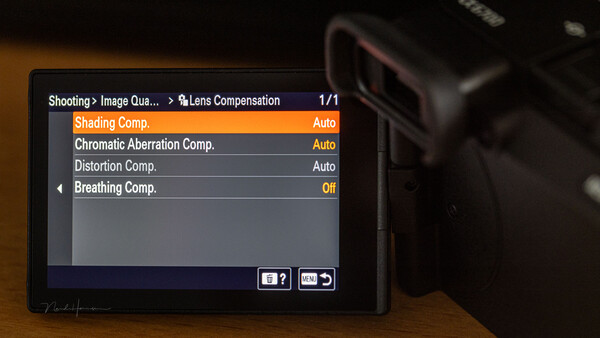 Screenshot of camera lens compensation settings menu showing shading, chromatic aberration, distortion, and breathing compensation options.
