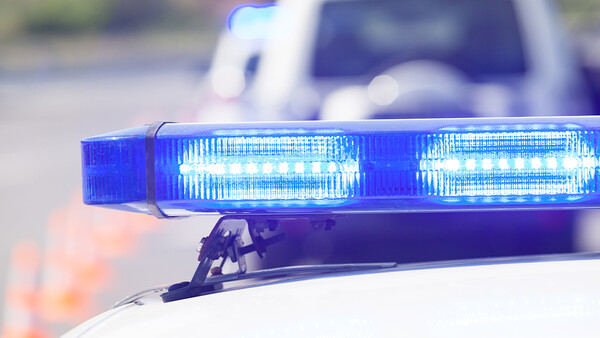 Blue LED emergency light bar on a police vehicle with bokeh background.