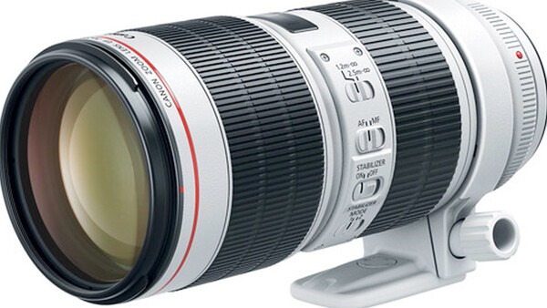 White telephoto zoom lens with black barrel sections and control rings, shown against white background.