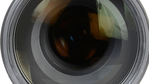 Close-up frontal view of a camera lens showing internal glass elements and aperture mechanism.