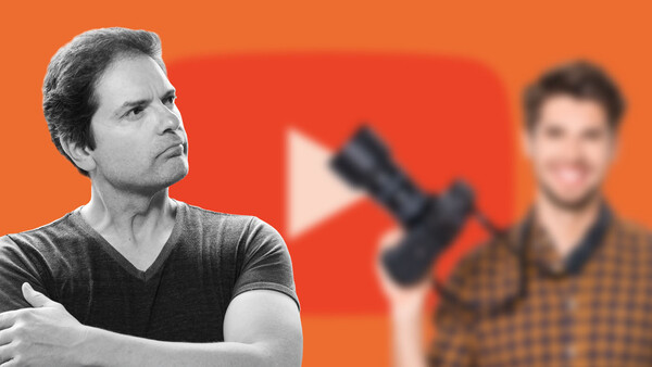 Man in dark v-neck shirt looking upward with thoughtful expression against orange background.