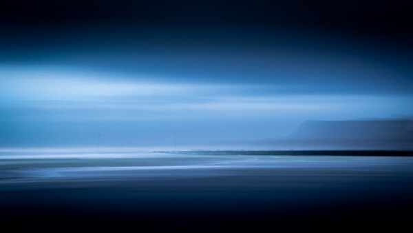 Minimalist seascape with horizontal bands of dark water, light blue sky, and thin luminous line dividing the composition.