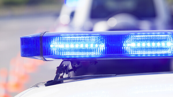 Blue LED emergency light bar mounted on a vehicle roof with bokeh background.