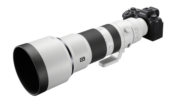 Sony mirrorless camera with white and black telephoto zoom lens mounted on top.
