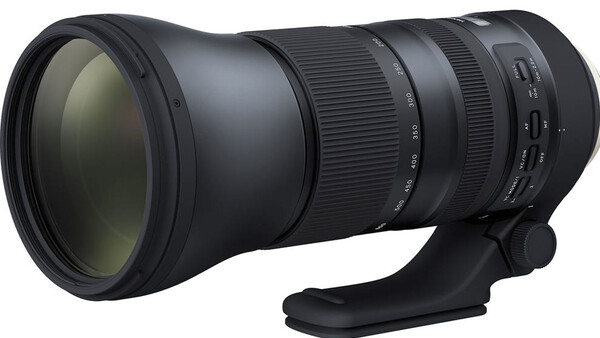 Black telephoto lens with tripod collar mounted on white background.