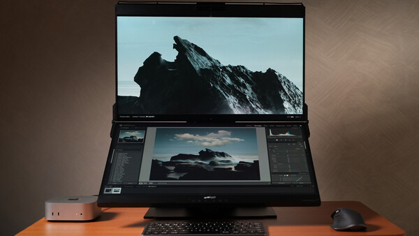 Laptop displaying mountain landscape photo with editing software panels open on secondary monitor.
