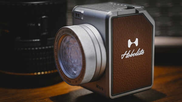 Hasselblad medium format camera with vintage lens and leather body on wooden surface.