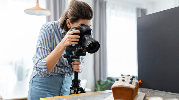 Female photographer shooting video with a professional camera mounted on a gimbal stabilizer.