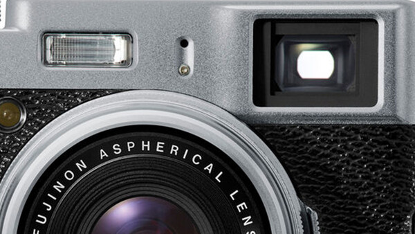 Close-up of a vintage rangefinder camera with Fujinon Aspherical lens and flash attachment.