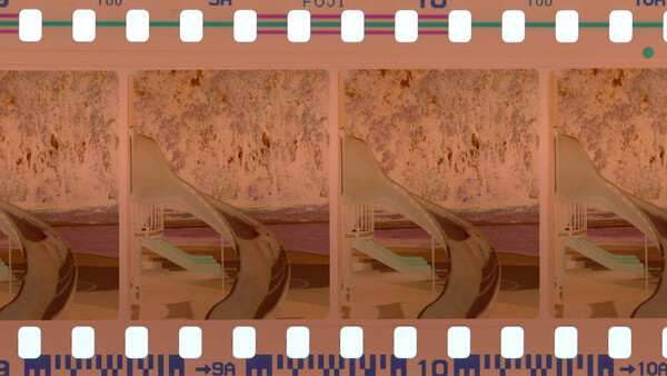 Film strip with expired color film showing degraded images of architectural interior with curved elements.