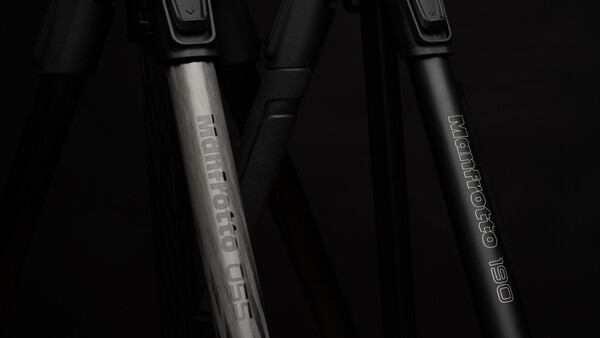 Two bicycle fork shock absorbers with text engravings on metallic stems against a dark background.