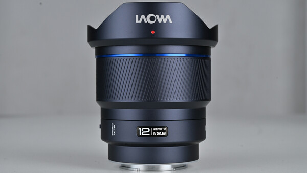 Laowa 12mm f/2.8 ultra-wide angle lens with black barrel and blue accent ring, shown in product display orientation.