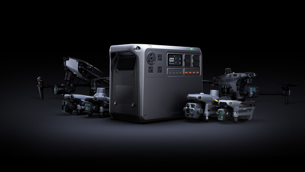 Portable power station surrounded by professional drones and cameras against a dark background.