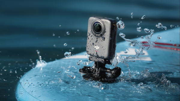 Action camera mounted on a blue surface with water splashing around it during a water sports activity.