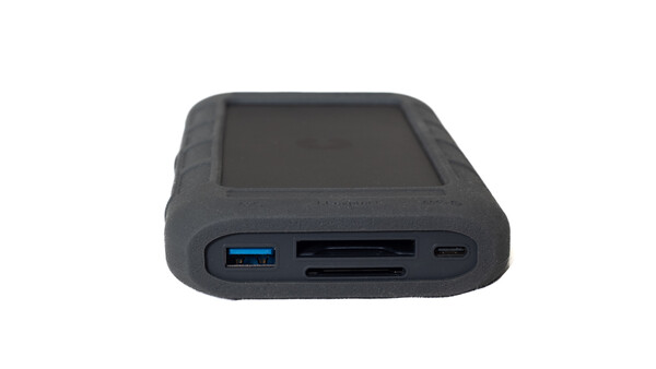 Rugged external hard drive with rubber bumper protection, USB and card reader ports visible.