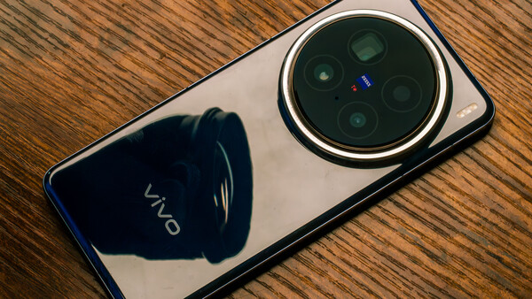 Vivo smartphone with quad camera system displayed on wooden surface, showing prominent circular camera module.