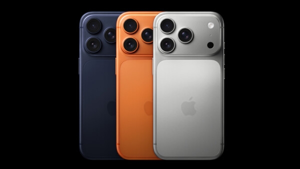 Three smartphones displaying triple rear camera systems in dark blue, orange, and silver finishes against a black background.